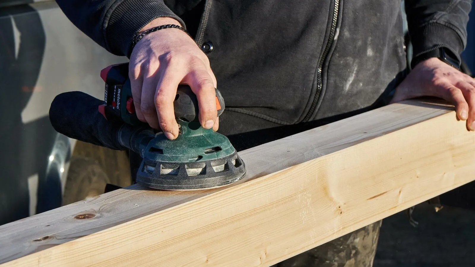 Handwerker benutzt den Metabo Multischleifer für eine Holzoberfläche.